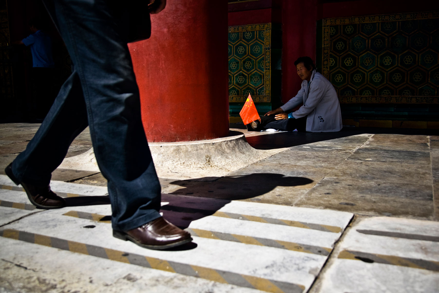 CHINA. Beijing, September 2012. A man asks for charity inside the Forbidden City.